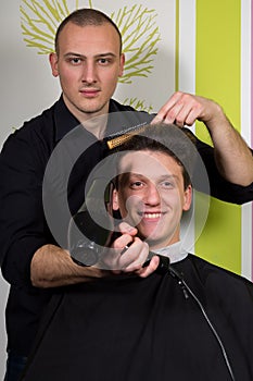 Men's hairstyling and haircutting with hair clipper and scissor