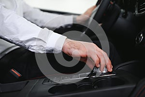 Men& x27;s hand crank controls the electric car driver shifting gears electric car& x27;s gear.