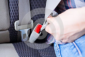 Men`s hand fastens the seat belt of the car