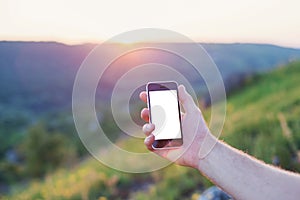 Men's hand hold the phone with the white screen