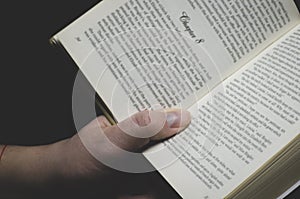 Men& x27;s hand holds an open book ready for reading