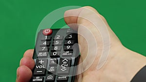 Men`s hand. Large remote control. Right hand. Green screen. Press the button.