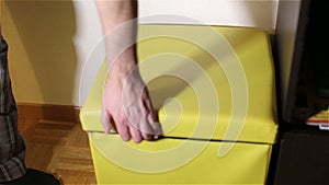 Men's hand opens a yellow square.