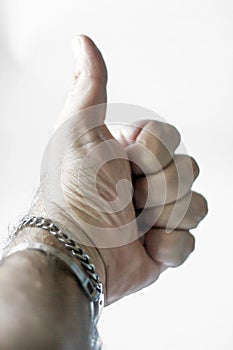 Men`s hand seen from the inside with the thumb upwards to indicate the now universal signal of the ok.