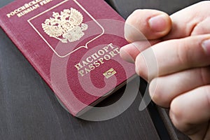 Men`s Hand shows the fico on passport backgound. Symbol of sanctions. Negative concept. Closeup