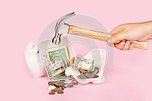 Men`s hand smashes with a hammer Piggy bank on pink background. mockup, template. Concept of financial crisis after coronavirus