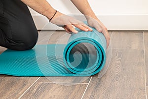 Men& x27;s hands close-up, unroll colorful mat for playing sports. Sport and healthy lifestyles concept