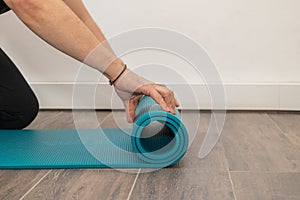 Men& x27;s hands close-up, unroll colorful mat for playing sports. Sport and healthy lifestyles concept