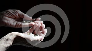 Men`s hands with coins. Contrast image on a dark background. Coin counting. Men`s hands with coins.