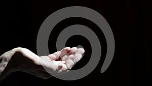 Men`s hands with coins. Contrast image on a dark background. Coin counting. Men`s hands with coins.