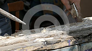 Men's hands dismantle the frames of an old rotten wooden window. Replacing an old window with a new one