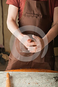 Men`s hands and dough close-up. Baking gingerbread Christmas and Easter gingerbread cookies. A man in the kitchen is preparing coo