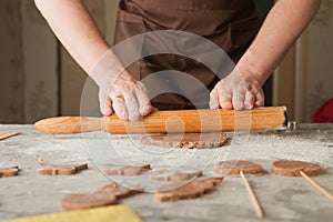 Men`s hands and dough close-up. Baking gingerbread Christmas and Easter gingerbread cookies. A man in the kitchen is preparing coo