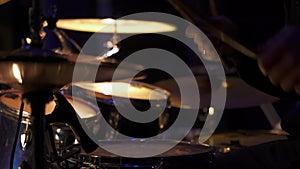 Men's hands in the frame, playing the drums on soundcheck on big concert hall stage