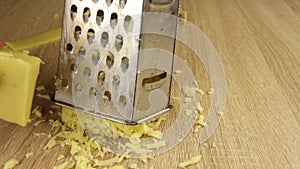 Men`s hands grate cheese on a metal grater