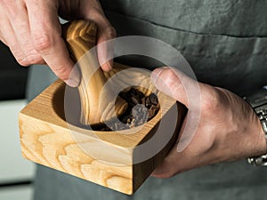 Men`s hands grind spices in a mortar