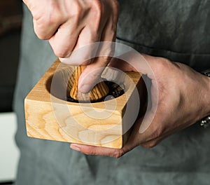 Men`s hands grind spices in a mortar