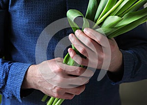 Men`s hands hold flowers. Man with flowers. Flowers for your beloved woman. A bouquet in hands. Date. Confession.