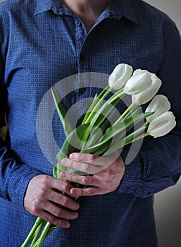 Men`s hands hold flowers. Man with flowers. Flowers for your beloved woman. A bouquet in hands. Date. Confession.