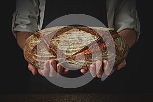 Men`s hands hold organic dark bread