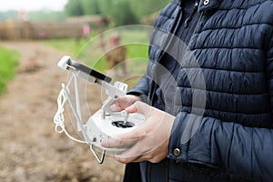 Men`s hands holding remote control of drone. Using technology