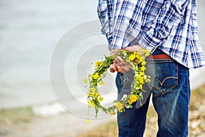 Men's hands holding yellow wreath, care, agriculture