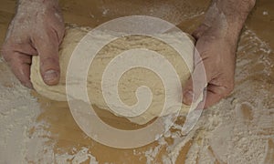 Men`s hands knead the dough.  Male baker