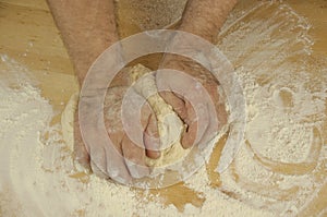 Men`s hands knead the dough.  Male baker