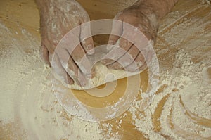 Men`s hands knead the dough.  Male baker