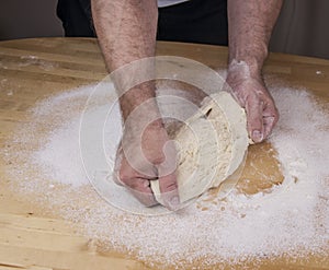 Men`s hands knead the dough.  Male baker