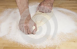 Men`s hands knead the dough.  Male baker