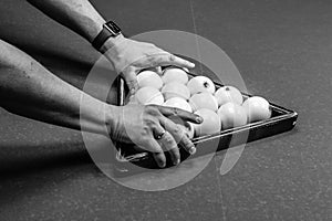 Men`s hands lay out a billiard triangle