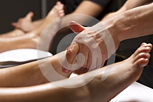 Men`s hands perform foot massage