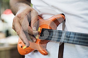 Men`s hands play on a toy electric guitar