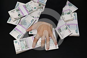 men& x27;s hands reach for wad of money. A million rubles on the black table. The concept of wealth, success, greed and