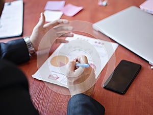 Men`s hands work with documents on the wooden table. Business concept.