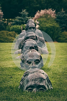 Men`s heads rising out of the lawn