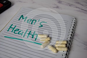 Men`s Health write on a book and keyword isolated on Office Desk. Healthcare/Medical Concept