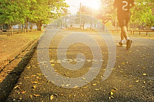 Men`s jogging in the Park at a distance of 400 meters to maintain internal strength. On the road, and the orange light of the Sun