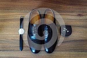 Men`s leather shoes, watches and cufflinks on the background of a brown table. Clothing accessories businessman. Concept