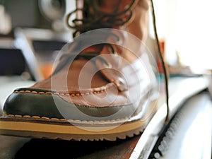 Men`s leather work boot sitting on desk.