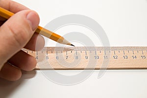 Men's left hand holding a pencil on over white photo