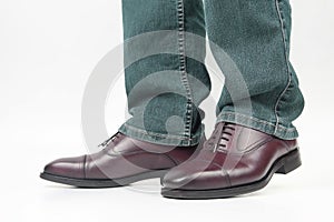 Men`s legs in jeans shod in classic brown Oxford shoes