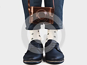 Men`s legs, vintage camera, socks and stylish shoes