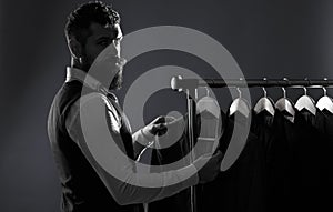 Men`s lothing, shopping in boutiques. Tailor, tailoring. Man suit, tailor in his workshop. Elegant man`s suits hanging photo