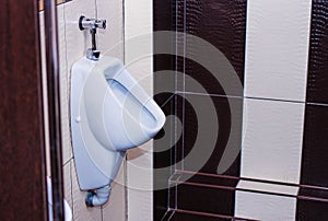 Men`s room with white urinal in line. Comfortable male toilet urinal, Modern clean public toilets