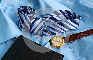 On a men`s shirt there is a purse, a watch, a tie