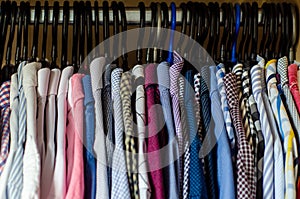 Men`s shirts on hangers in the wardrobe