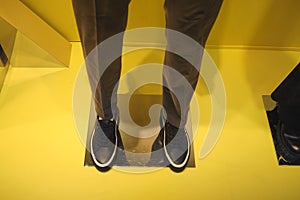 Men's shoes and accessories, shop window on a yellow background. Fashionable men's clothing.