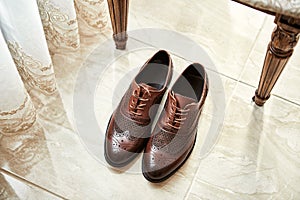 Men`s shoes lie on the floor. Different accessories of businessman for creating style of  people on  wooden background